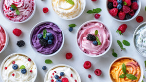 Assorted bowls of yogurt with fruits and berries on a white background